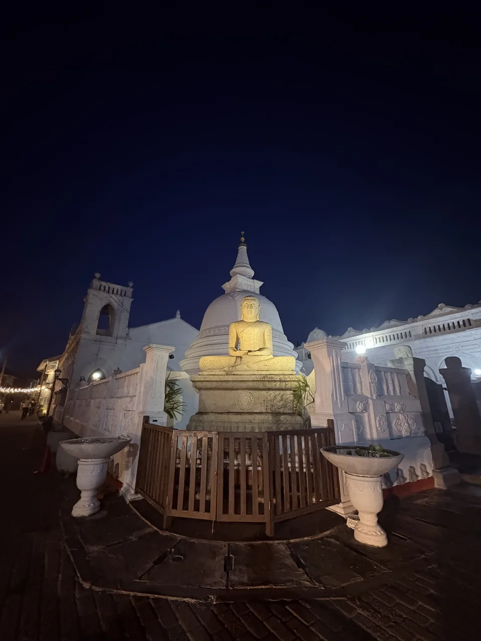 Illuminated white stupa at night inside Galle Fort