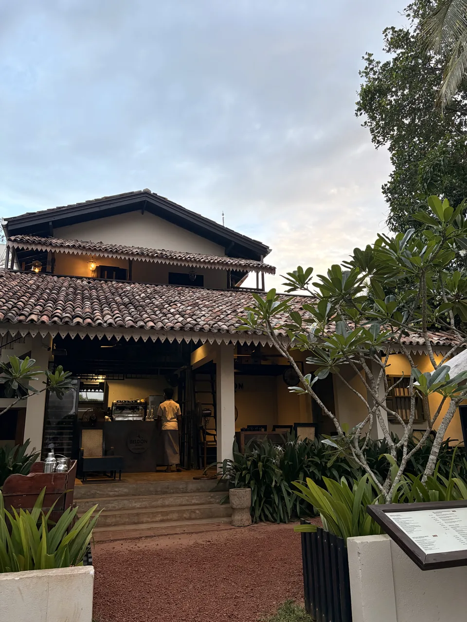 Cafe terrace with tiled roof and frangipani trees in Hiriketiya, Dikwella