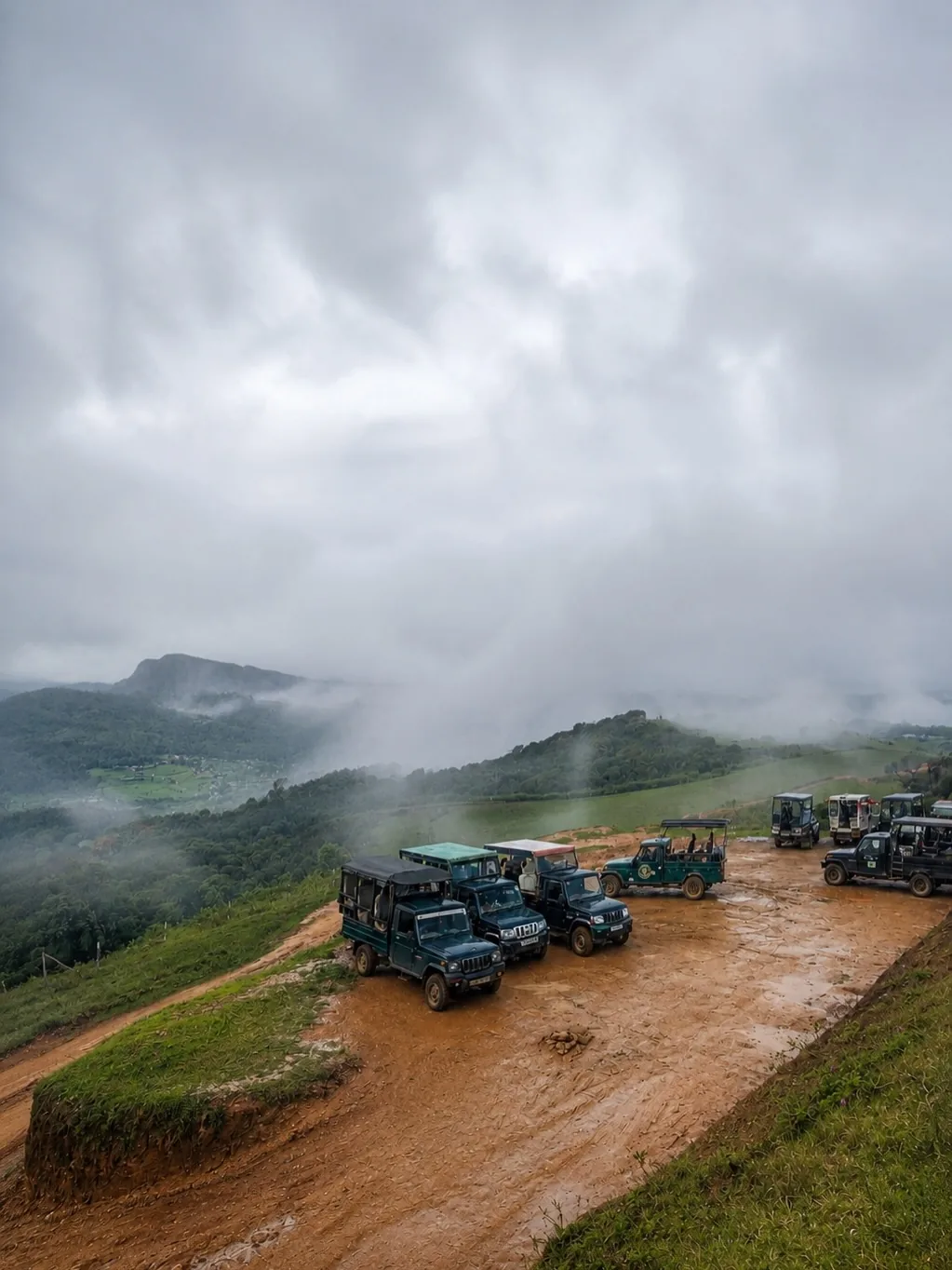 Safari jeeps parked at the Moon Plains viewpoint in the mist