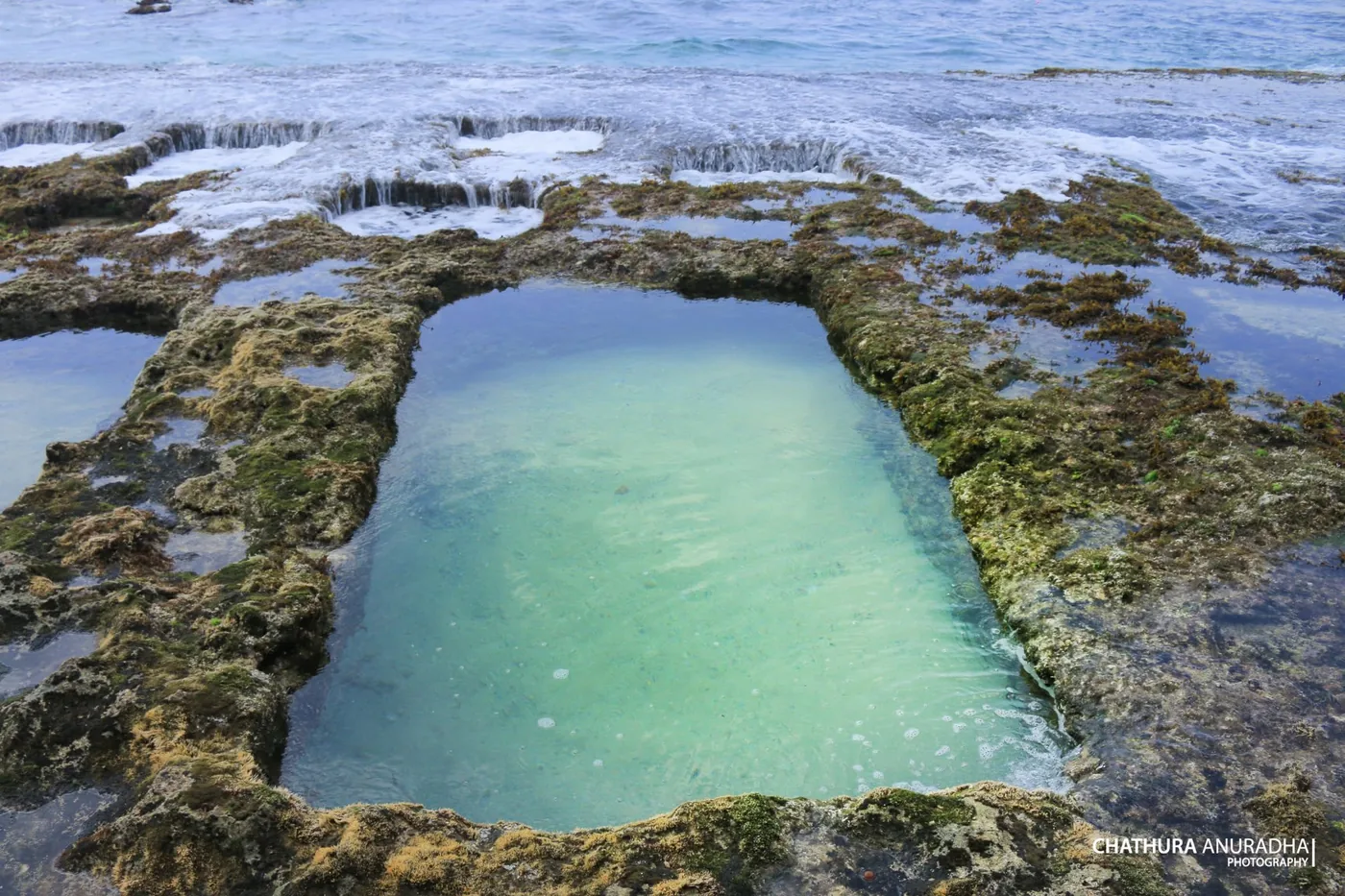 A single rectangular rock pool filled with clear seawater at Talpe Beach