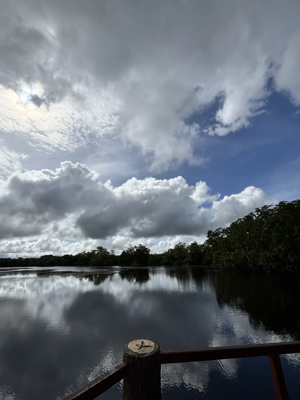 Still lake reflecting dramatic clouds, seen from the rest area deck inside Wilpattu